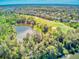 Aerial view of a beautiful landscape of a golf course and a pond near houses and woods at 441 Mayfair Dr, Kissimmee, FL 34759