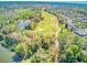 Aerial view of a golf course surrounded by trees, ponds, and houses in the neighborhood at 441 Mayfair Dr, Kissimmee, FL 34759