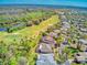 Aerial view of homes near a golf course, pond, and woods with green space at 441 Mayfair Dr, Kissimmee, FL 34759