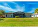 Expansive backyard with a screened lanai, lush green lawn, and serene surroundings at 441 Mayfair Dr, Kissimmee, FL 34759