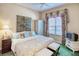 Cozy bedroom with a floral curtain, framed artwork, and white furniture at 441 Mayfair Dr, Kissimmee, FL 34759