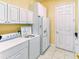 Laundry room with white cabinetry, washer, dryer, and a white refrigerator at 441 Mayfair Dr, Kissimmee, FL 34759