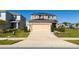 Well-manicured lawn leads up to this tan two-story home with a tan garage at 1134 Forest Gate Cir, Haines City, FL 33844