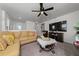Comfortable living room showcasing a sofa, modern entertainment center, and contemporary ceiling fan at 1134 Forest Gate Cir, Haines City, FL 33844