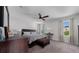 Serene main bedroom with a ceiling fan, a comfortable bed, and large windows overlooking lush greenery at 1134 Forest Gate Cir, Haines City, FL 33844