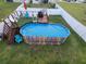 Aerial view of an above ground pool with a deck, chairs, and a white privacy fence at 1134 Forest Gate Cir, Haines City, FL 33844