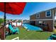 Inviting backyard with above-ground pool, deck, artificial turf, and red umbrella, perfect for outdoor relaxation and entertaining at 1134 Forest Gate Cir, Haines City, FL 33844