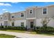 Two-story townhome with gray siding, landscaping, and a paved walkway at 1330 Blazing Star Ln, Davenport, FL 33837