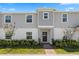 Two-story townhome with gray siding, landscaping, and a brick walkway at 1330 Blazing Star Ln, Davenport, FL 33837