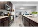 Modern kitchen with dark cabinets, stainless steel appliances, and an island at 1330 Blazing Star Ln, Davenport, FL 33837