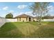 Large, grassy backyard featuring well-maintained lawn and a white fence line at 2703 Gullane Ct, Kissimmee, FL 34746