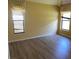 Bedroom with hardwood floors, two large windows with blinds, and yellow walls at 2703 Gullane Ct, Kissimmee, FL 34746