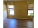Bedroom with hardwood floors, two large windows with blinds, and yellow walls at 2703 Gullane Ct, Kissimmee, FL 34746