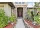 Inviting entrance with stone archway, lush greenery, and a pathway leading to the front door at 2703 Gullane Ct, Kissimmee, FL 34746