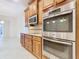 Modern kitchen features stainless steel appliances and wood cabinets at 676 Villa Park Rd, Kissimmee, FL 34759