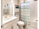 Cozy bathroom with a single vanity, toilet, and a shower-tub combination enclosed with a decorative curtain at 2201 Palm Tree Dr, Poinciana, FL 34759