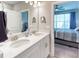 Elegant bathroom with a double vanity, sleek fixtures, and a doorway view into an adjacent bedroom at 2201 Palm Tree Dr, Poinciana, FL 34759