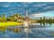 Picturesque pond view featuring a beautiful water fountain, lush greenery, and a serene open sky at 2201 Palm Tree Dr, Poinciana, FL 34759