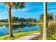 A serene pond view with a stone bridge, lush greenery, and clear blue sky, creating a peaceful landscape at 2201 Palm Tree Dr, Poinciana, FL 34759