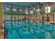 A large, well-lit indoor swimming pool with multiple lanes, perfect for exercise and recreation at 2201 Palm Tree Dr, Poinciana, FL 34759