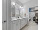 Bathroom featuring a double sink vanity, white cabinets, and a view into the walk-in closet at 3200 Songbird Cir, Harmony, FL 34773