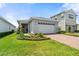 Charming single-Gathering home with a well-manicured lawn, brick driveway, and vibrant yellow front door at 3200 Songbird Cir, Harmony, FL 34773