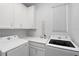 Well-equipped laundry room with white cabinetry, modern washer and dryer, and ample counter space at 3200 Songbird Cir, Harmony, FL 34773