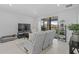 Bright living room with modern furniture, tile floors, and sliding glass doors to the patio at 3200 Songbird Cir, Harmony, FL 34773