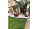 Landscaped townhouse entrance with red flowers and palm trees at 2031 Balboa Way, Kissimmee, FL 34741