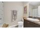 Cozy bathroom with a single sink vanity, framed art, and neutral colored walls at 3359 Bellezza Ct, Kissimmee, FL 34746