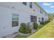 View of townhome exterior with white walls and green grass at 3359 Bellezza Ct, Kissimmee, FL 34746