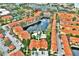 Aerial view of resort community featuring a tranquil lake, swimming pool, and red-tile roofed buildings at 6141 Metrowest E Blvd # 303, Orlando, FL 32835