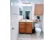 Bright bathroom featuring a wood vanity and a toilet with a shelf, providing convenient storage at 6141 Metrowest E Blvd # 303, Orlando, FL 32835