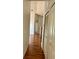 Hallway view with wooden floors, a linen closet and a glimpse into other rooms showcasing the home's layout at 6141 Metrowest E Blvd # 303, Orlando, FL 32835