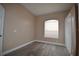 Bright bedroom with wood-look floors, window and closet at 2221 The Oaks Blvd, Kissimmee, FL 34746