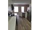 Kitchen view showcasing stainless steel appliances, white cabinets, and modern countertops with wood-look floors at 2221 The Oaks Blvd, Kissimmee, FL 34746