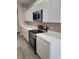 Bright kitchen with stainless steel appliances, white cabinets and countertops with wood-look floors at 2221 The Oaks Blvd, Kissimmee, FL 34746