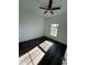 This bedroom features a ceiling fan, dark wood-look floors, and a window letting in natural light at 5115 Old Highway 37, Lakeland, FL 33811