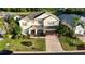 Aerial view of a home showing its landscaped lawn, paved driveway and proximity to a serene pond at 1387 Lexington Ave, Davenport, FL 33837