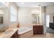 Bright bathroom featuring a large tub, double vanity sinks, and tile flooring at 1387 Lexington Ave, Davenport, FL 33837