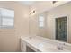 Bright bathroom featuring a double sink vanity, a large mirror, and natural light at 1387 Lexington Ave, Davenport, FL 33837