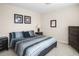 Comfortable bedroom features neutral walls, carpet, and a queen-sized bed with striped bedding at 1387 Lexington Ave, Davenport, FL 33837