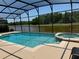 Enclosed pool and spa offer a relaxing outdoor oasis with views of the adjacent water feature at 1387 Lexington Ave, Davenport, FL 33837