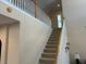 A well-lit staircase with neutral colors and a wooden handrail leading to the second floor at 1387 Lexington Ave, Davenport, FL 33837