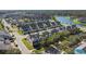 Community aerial view featuring gray townhomes, community pond, and landscaped streets at 13712 Summerport Village Pkwy, Windermere, FL 34786