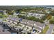 Aerial view of modern townhomes, lush trees, and community lake at 13712 Summerport Village Pkwy, Windermere, FL 34786