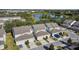 Community aerial view with townhomes featuring attached garages, lush landscaping, and a lake at 13712 Summerport Village Pkwy, Windermere, FL 34786