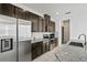 Kitchen with granite countertops, stainless appliances, and dark cabinets at 13712 Summerport Village Pkwy, Windermere, FL 34786