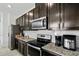 Kitchen with stainless steel appliances, dark wood cabinets, and granite countertops at 13712 Summerport Village Pkwy, Windermere, FL 34786