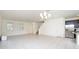 Bright living room features tile floors and a modern chandelier, complemented by natural light from large windows at 13712 Summerport Village Pkwy, Windermere, FL 34786